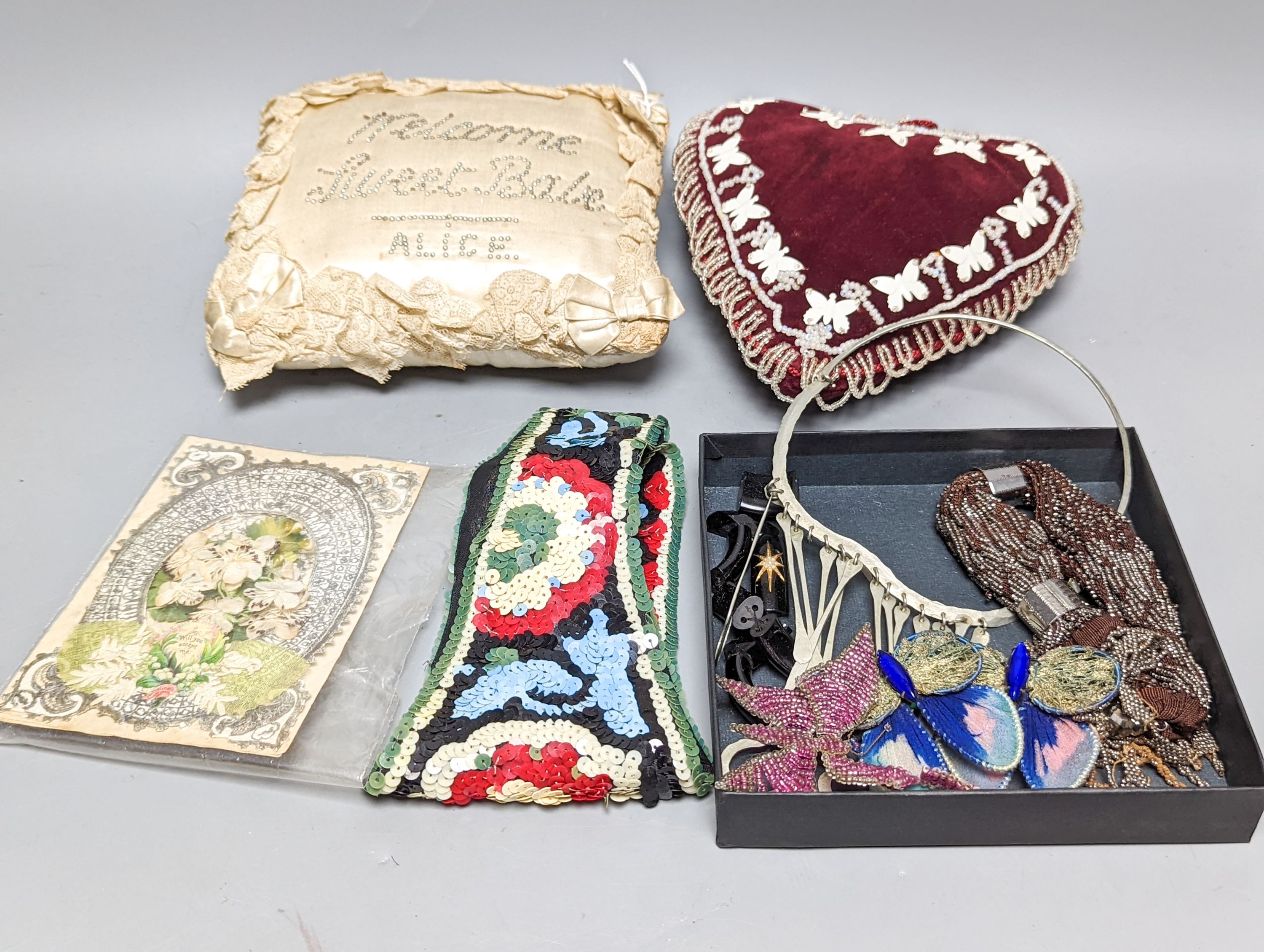 A cream silk pin baby cushion, a valentine cushion, a miser's purse, appliques and sequin collar